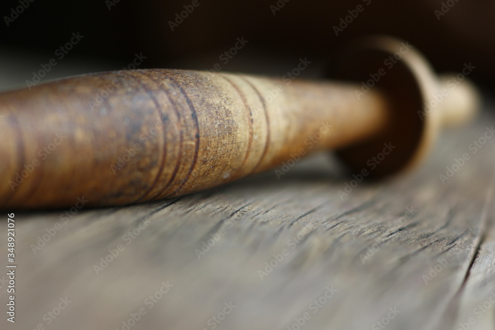 an old knitting spindle on a structural table made of cracked wood an old knitting spindle on a structural table made of cracked wood