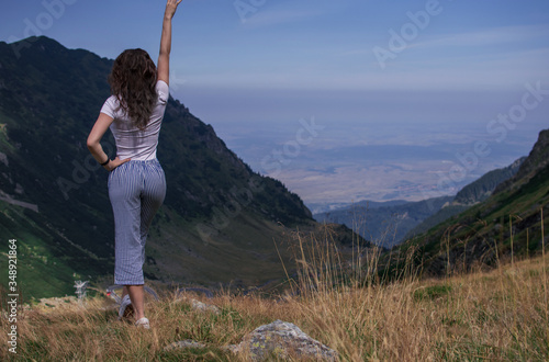 Girl Traveler on mountain summit enjoying aerial view hands raised over clouds. Travel Lifestyle concept adventure happiness freedom emotions. Joyfully. space for text
