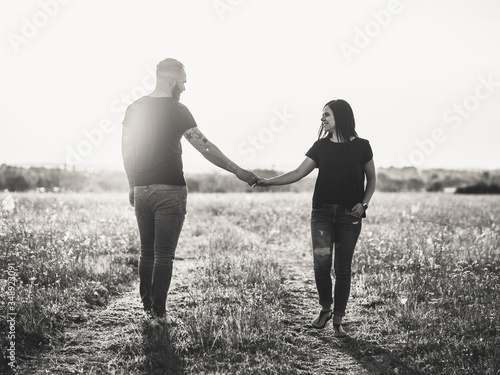young couple walking in park at sunset