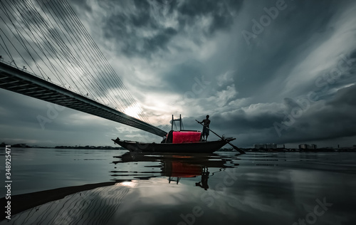 Billede på lærred Boat on a river under the monsoon sky in Kolkata