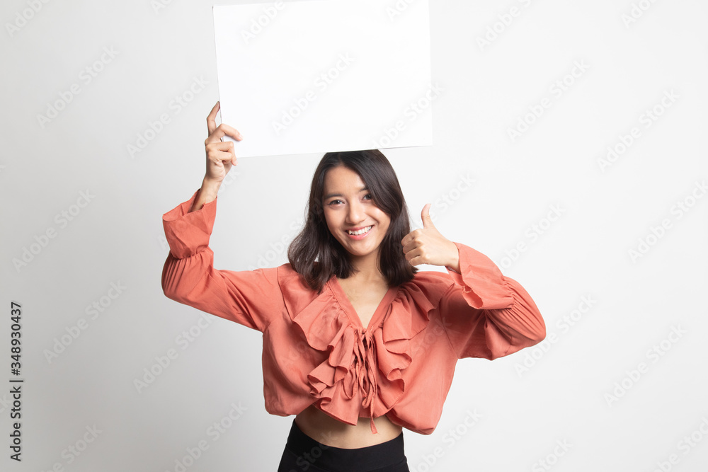 Young Asian woman show thumbs up with white blank sign .