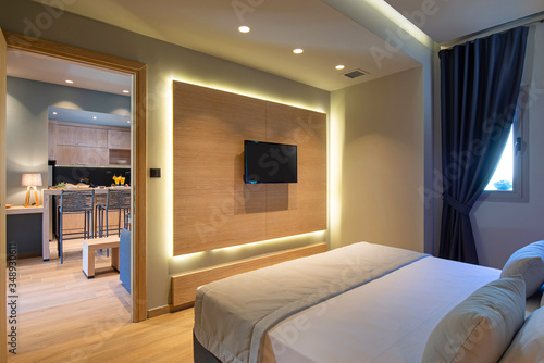 Modern grey, blue, wooden bedroom in small studio apartment. Contemporary minimalistic interior of hotel flat room with copy space tv panel