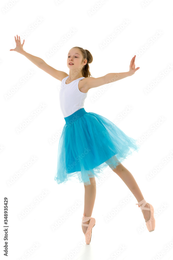 Cute little girl in a tutu and pointe shoes dancing in the studi Cute little girl in a tutu and pointe shoes dancing in the studi