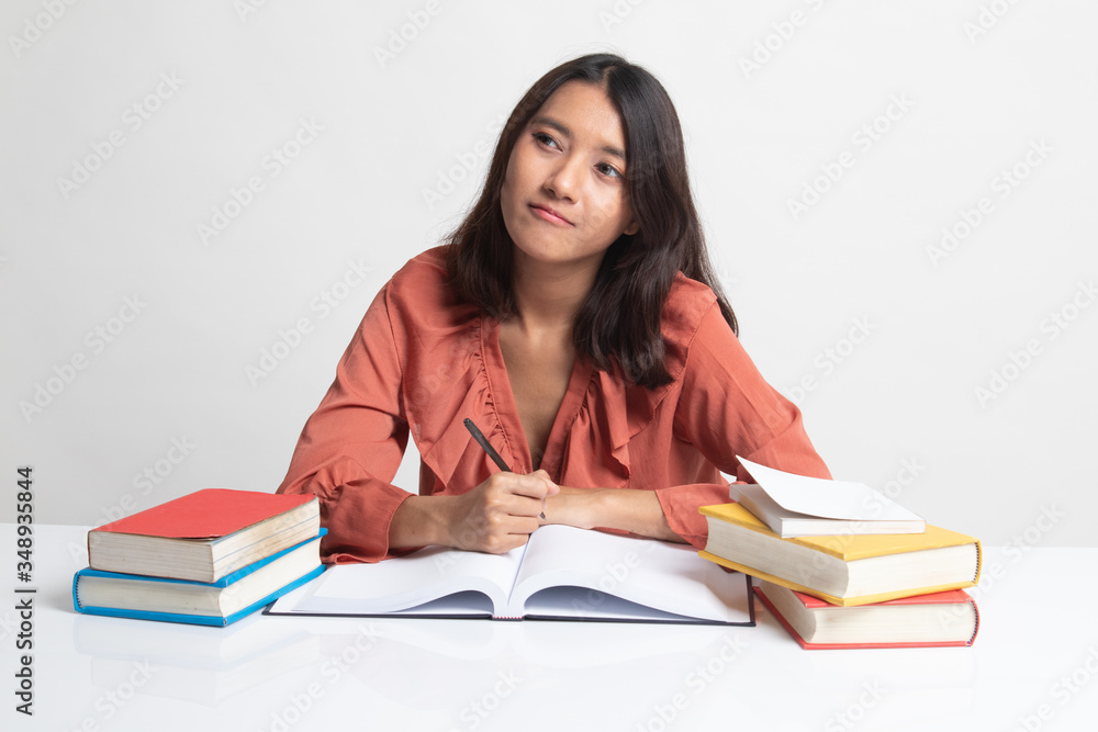 Young Asian woman read a book with books on table . Young Asian woman read a book with books on table .