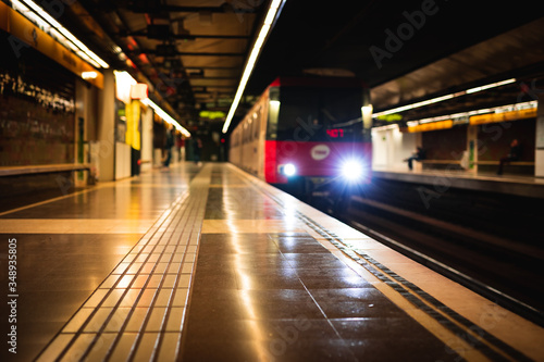 Train arriving at an empty subway train station blurred