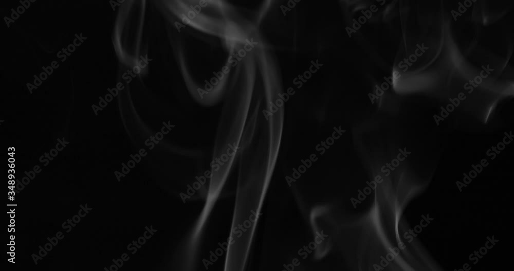 White smoke floating through space against black background White smoke floating through space against black background