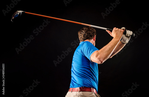 Close-up of a golf player perfecting the swing isolated on dark background