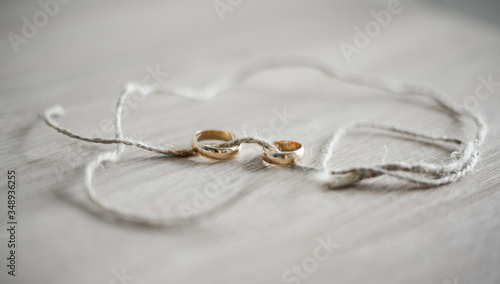  Wedding rings strung on a thread on a table