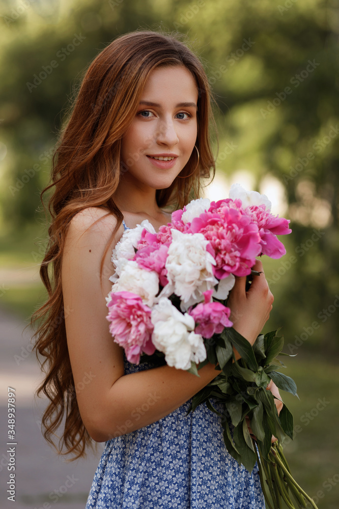 portrait of a girl with peonies in the park