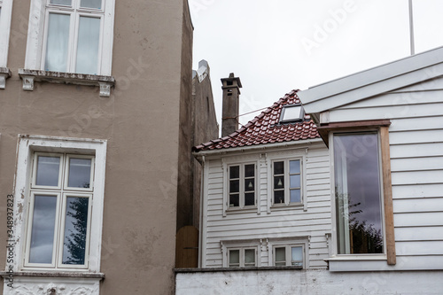 Small white traditional old nordic house hidden in streets of Bergen, Norway