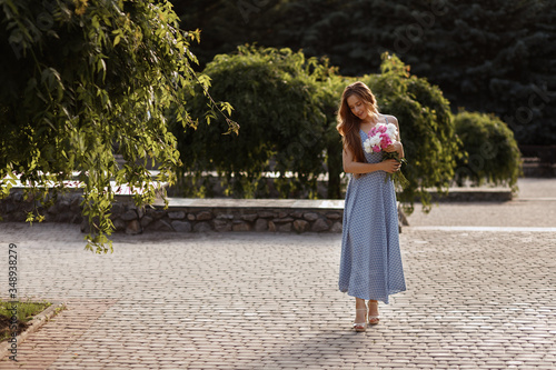 model in the evening on a summer walk. girl with a bouquet of flowers. blurred background, concept © Екатерина Арцыбашева
