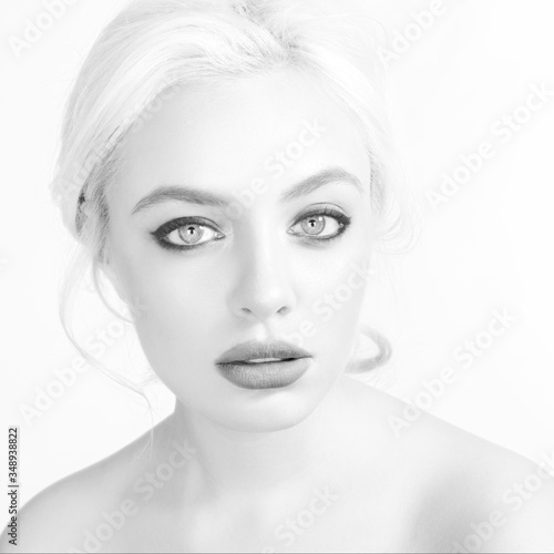 Beautiful blonde woman with make-up on light gray background.