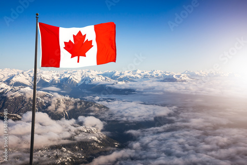 Canadian National Flag Composite over an Aerial View of Remote Mountain Landscape during sunny morning. Background taken near Vancouver, British Columbia, Canada.