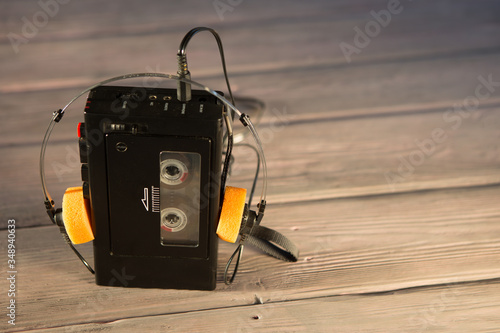 Old portable cassette player and headphones on a wooden background photo