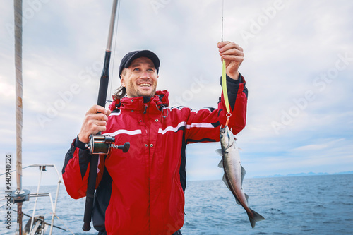 A sailor with a trophy fish caught on the boat in open sea in Norway