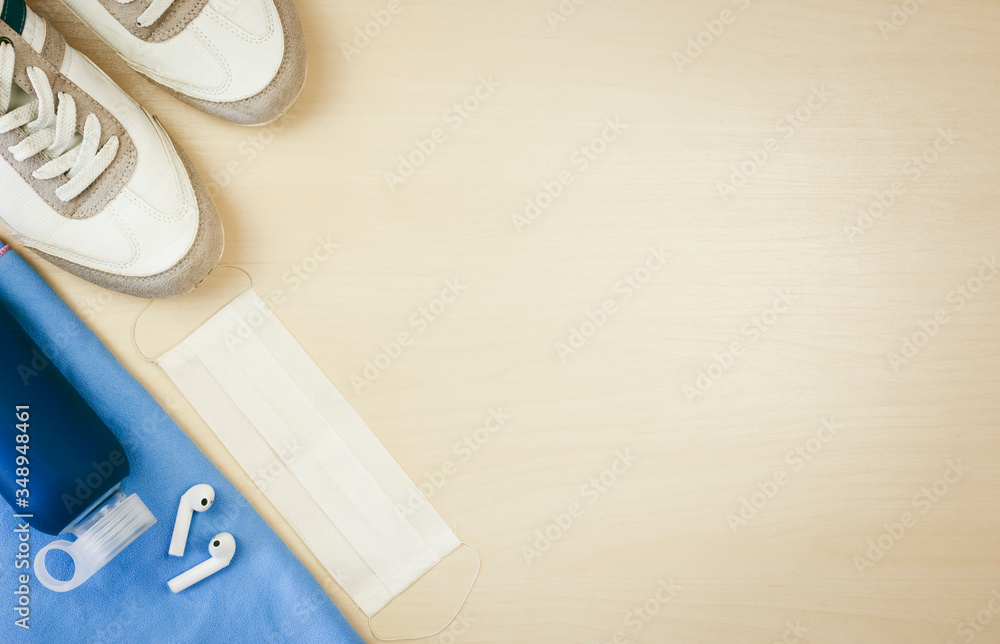 Flat lay of sports accessories with white protective mask.