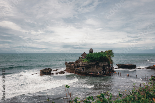 Sacred temple of Tanah Lot on a stone rock in the ocean.