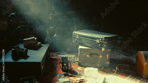 Old vintage stuff, suitcases, cameras, glass botles, rack with books, bicylce, and other objects are kept in the old mysterious attic - the place where magic things may happen, Zoom in, Slow motion.