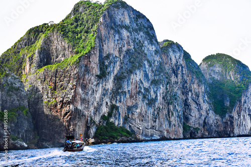 Phi phi island in thailand mountains landscape over the sea and motorboat sailing next to it 