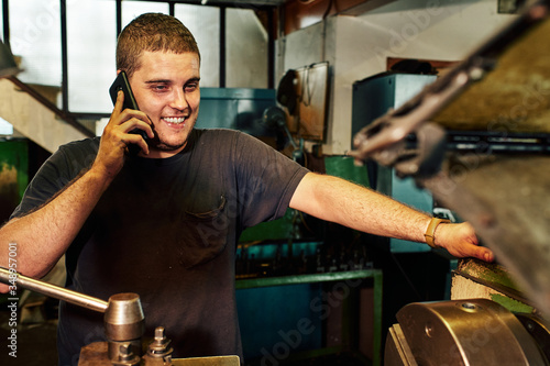 Tableau sur toile Professional machinist : man operating lathe grinding machine