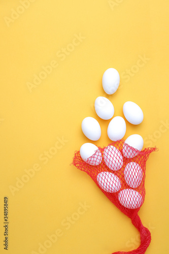 Eggs,Eggs come out of the net red bag.top view yellow background easter egg