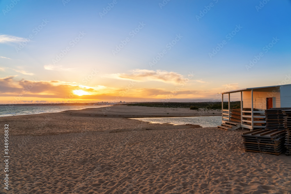 Landscape of a beautiful sunset on the ocean, with a horizon with a blue sky and a house on the sand. Portugal. Landscape of a beautiful sunset on the ocean, with a horizon with a blue sky and a house on the sand. Portugal.