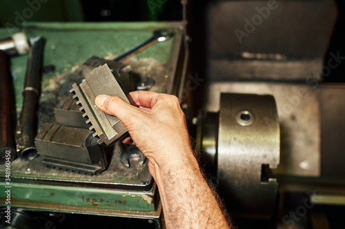 Professional machinist : man operating lathe grinding machine