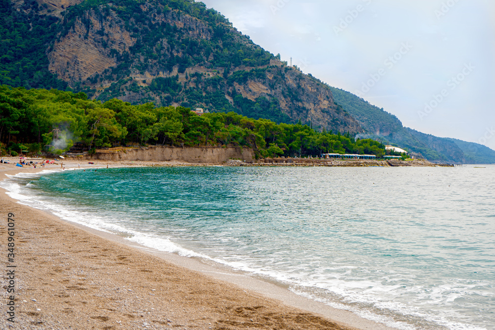 sandy beach of the mediterranean sea with mountain views and turquoise water in Turkey