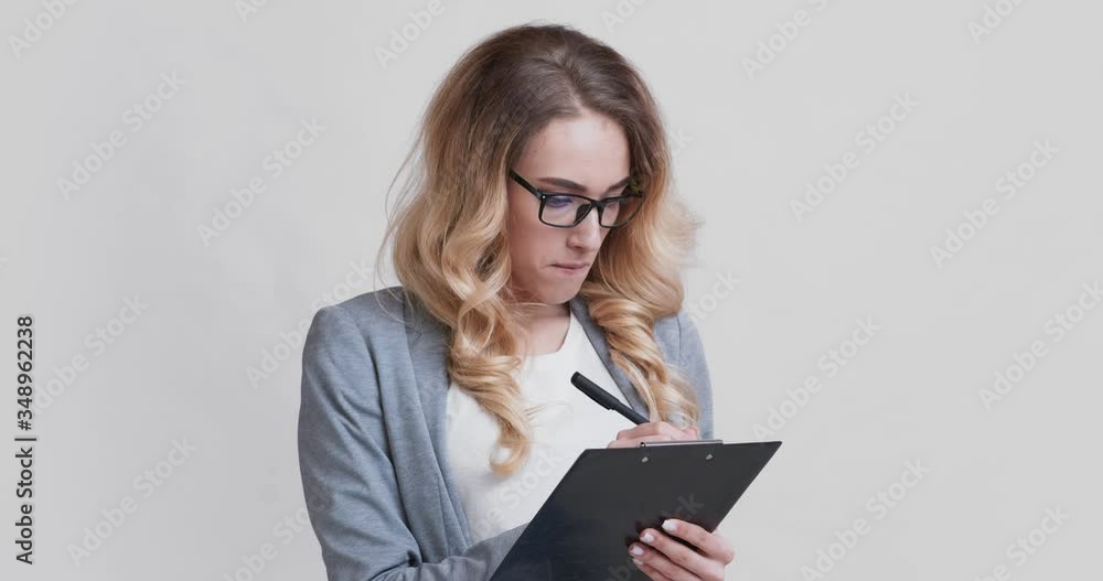 Focused business woman taking notes, writing checklist Focused business woman taking notes, writing checklist