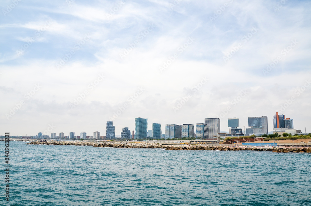 View from the sea in Spanish coastline and city of Barcelona with new architecture and modern buildings.