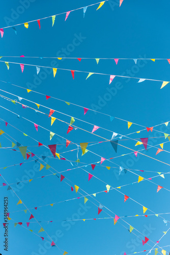 Colored pennants hanging on the street on a sunny day photo