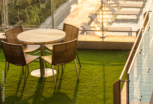 Empty Wooden Tea table on rooftop garden by swimming pool in the evening