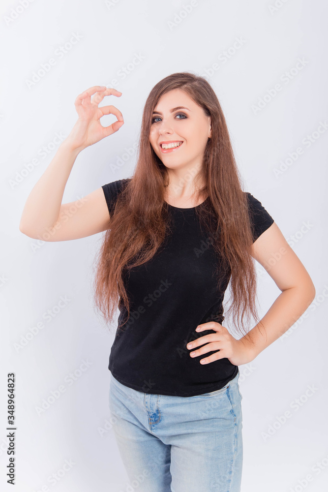 Portrait of pretty woman in black t-shirt showing okay gesture isolated on white background. Portrait of pretty woman in black t-shirt showing okay gesture isolated on white background.