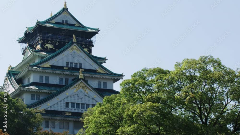 Osaka Castle in Japan on a sunny day with green trees and light blue sky Osaka Castle in Japan on a sunny day with green trees and light blue sky