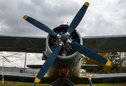 Engine, propeller and wing of an old vintage airplane against cloudy sky 