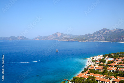 Pirate ship drifts in the blue lagoon, top view, coast with hotel houses, a popular tourist destination, the Mediterranean Sea, Oudeniz, Mugla, Turkey, banner