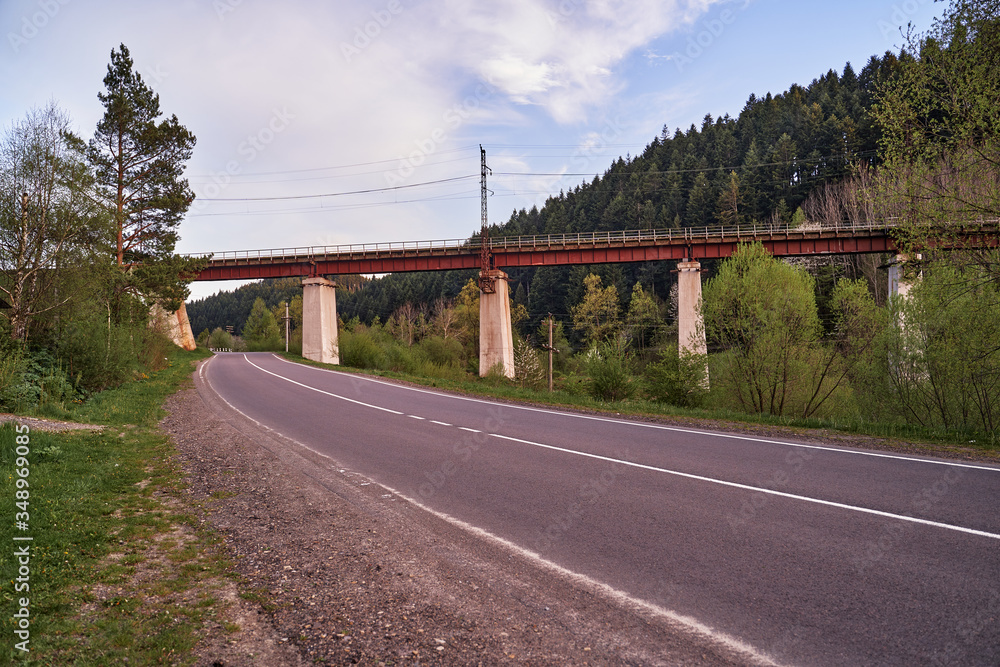 Naklejka premium railway bridge across the road in the mountains is a beautiful building