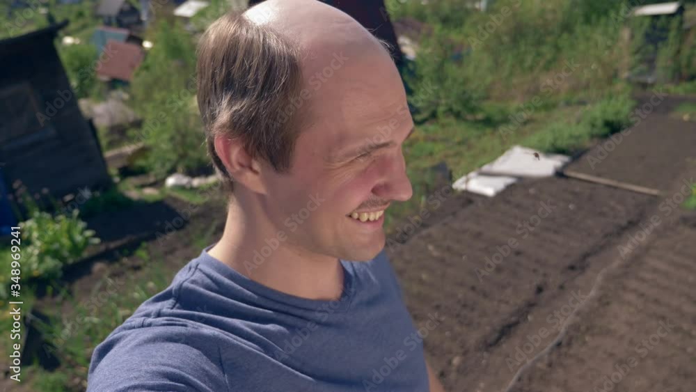 portrait, balding young man in the countryside looking at the camera, smiling portrait, balding young man in the countryside looking at the camera, smiling