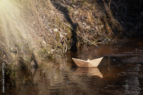 craft paper boat on water, spring snowmelt, paper boat sailing along a stream