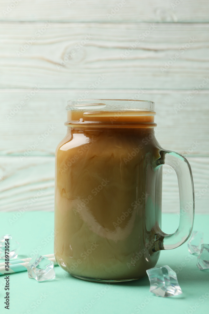 Jar of ice coffee, ice cubes and straws on mint table Jar of ice coffee, ice cubes and straws on mint table