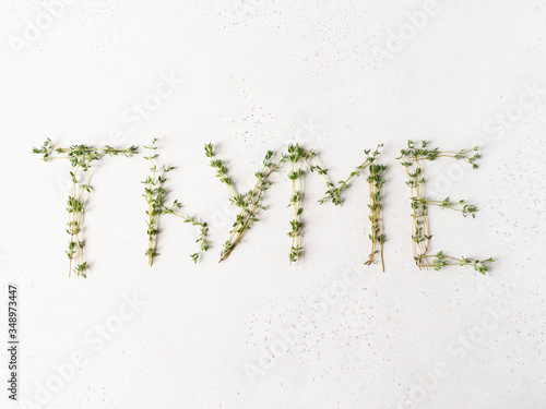 Thyme - word made from sprigs of natural fresh thyme on light background. Top view