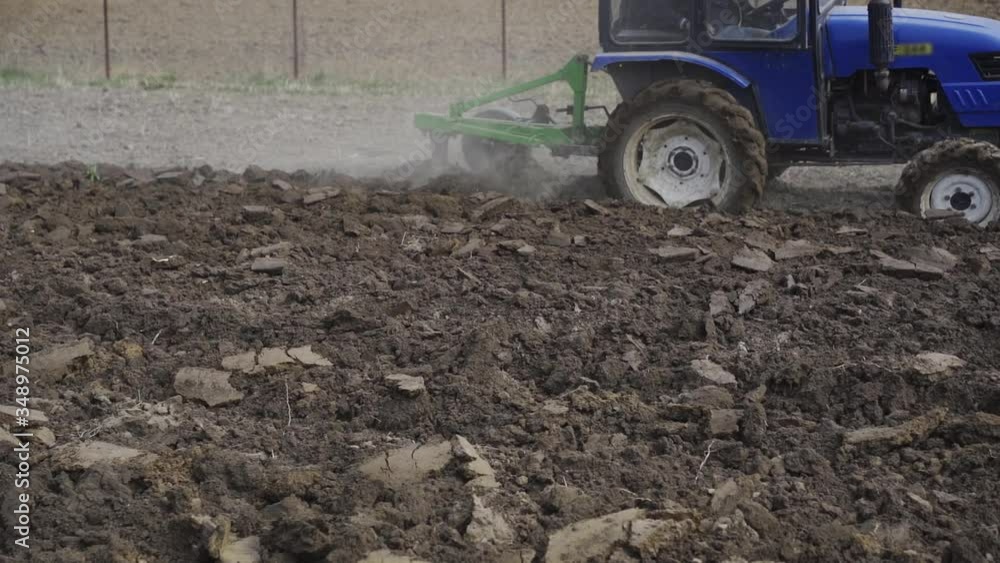 Tractor prepare the land for planting of the earth. planting vegetables for food. Home agriculture Tractor prepare the land for planting of the earth. planting vegetables for food. Home agriculture