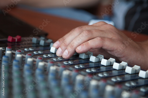 Hand adjusting audio mixer