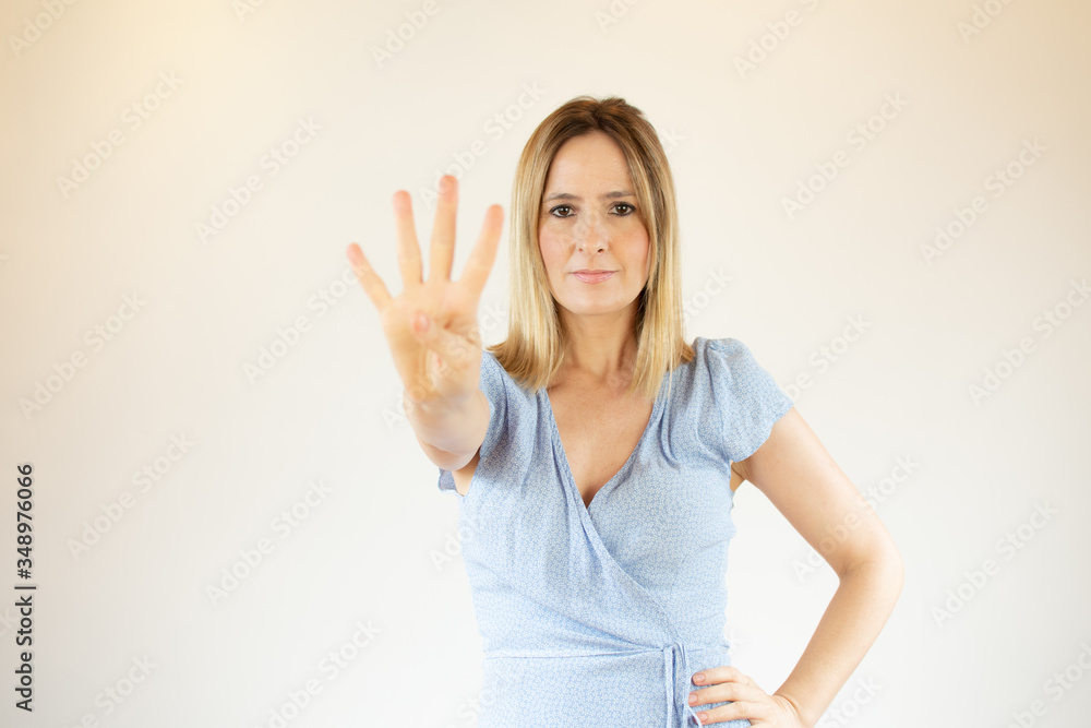 Young pretty woman wearing blue dress and making fingers up gesture Young pretty woman wearing blue dress and making fingers up gesture