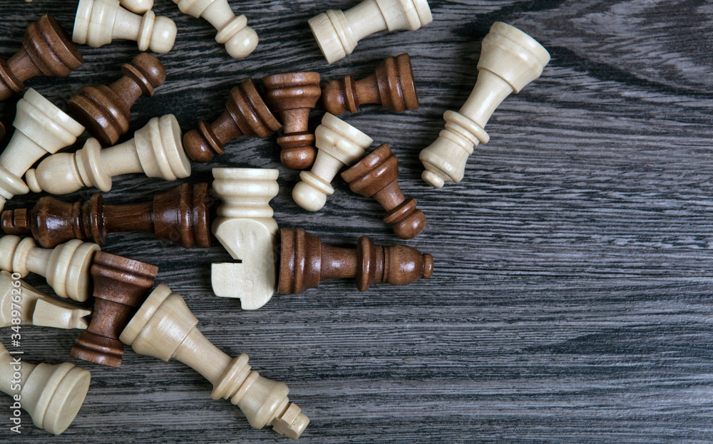 scattered chess pieces on a wooden background scattered chess pieces on a wooden background