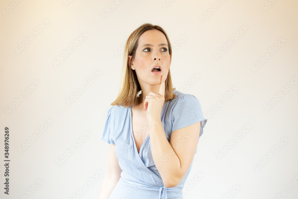 Beautiful woman wearing blue dress making thoughtful gesture Beautiful woman wearing blue dress making thoughtful gesture