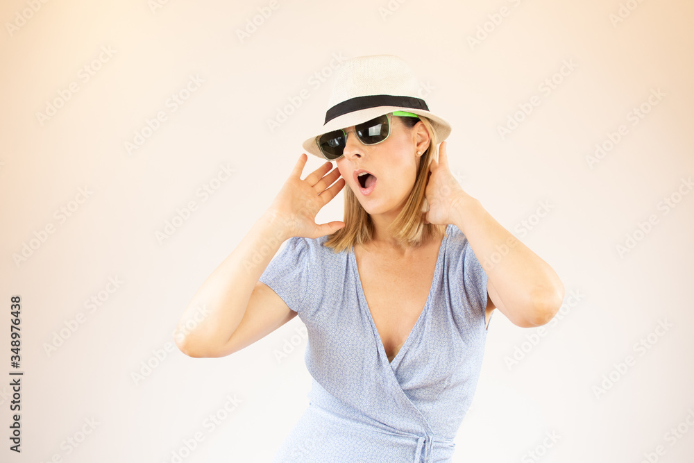 Young woman wearing hat and glasses making surprised gesture on vacation Young woman wearing hat and glasses making surprised gesture on vacation