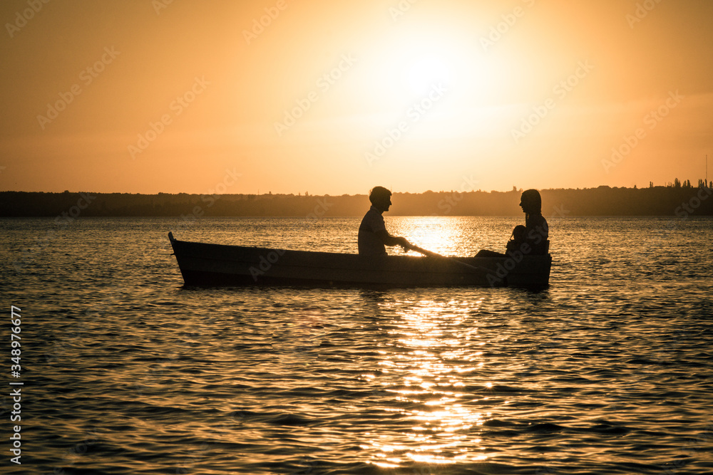 silhouette of people in a boat at sunset