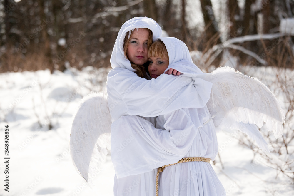 Obraz premium girls with white hoodies with angel wings on a winter background