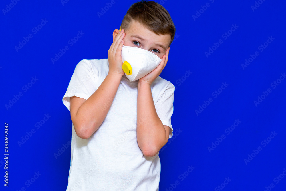 Front view close-up Horizontal portrait of The child's hands to the head.Disease protection for kids. Surgical masks for coronavirus prevention. Bright blue background.Copy space,banner.
